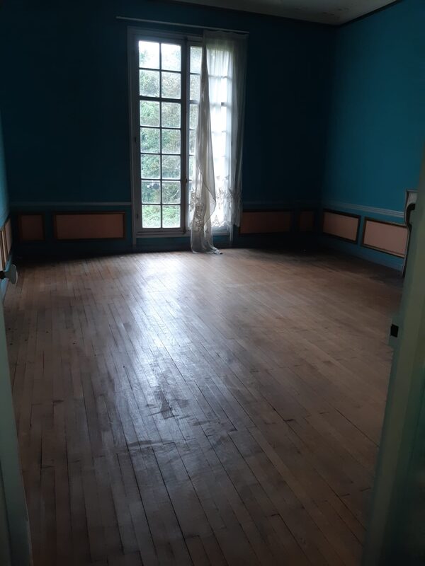 Chambre vidée après débarras, parquet dégagé